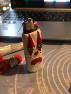 a white and red lighter sitting on top of a table next to a laptop