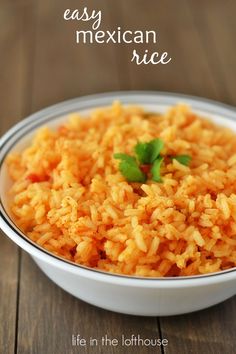 mexican rice in a white bowl with cilantro garnish on the side