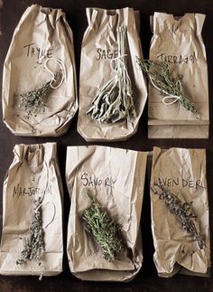 six bags with herbs on them sitting on a table