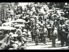 an old black and white photo of people walking down the street