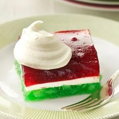 a piece of cake with whipped cream on top is sitting on a white plate next to a fork