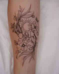 a woman's leg with flowers and a fish tattoo on the side of her thigh