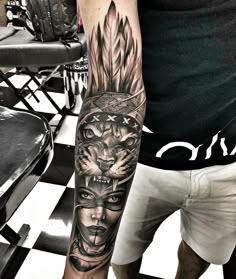 a man's arm with tattoos on it and an image of two faces in the middle