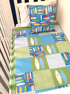 a crib bed with a green and blue quilt