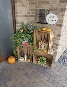 three wooden crates with pumpkins, gourds and other decorations on the front porch