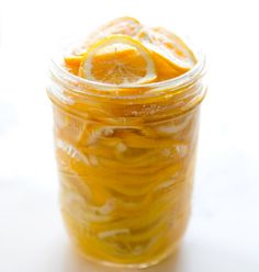 a jar filled with sliced oranges on top of a table