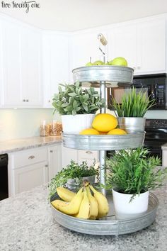 three tiered tray with fruits and vegetables in the kitchen