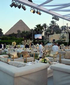 an outdoor event with couches and tables set up in front of the pyramids