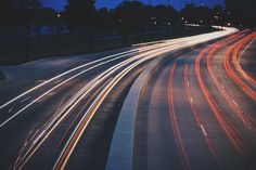 long exposure photograph of traffic on highway at night with city lights in the foreground