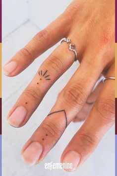 a woman's hand with a small tattoo on the middle finger and an arrow in the middle