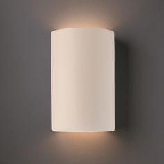 a white wall light mounted on the side of a gray wall next to a lamp