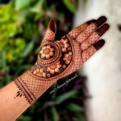 a woman's hand is decorated with henna and circular designs on the palm