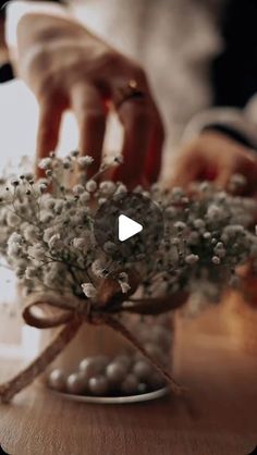 a person is arranging flowers on a table