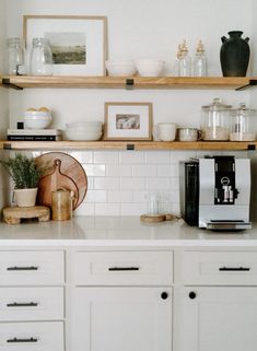 the shelves above the kitchen counter are filled with dishes, cups and utensils