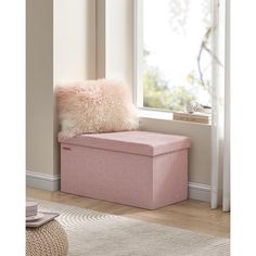 a pink storage box sitting in front of a window with a pillow on top of it