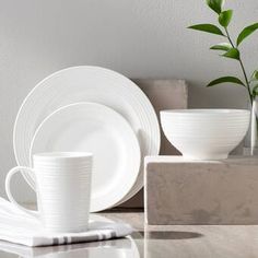 white dishes and cups are sitting on a table