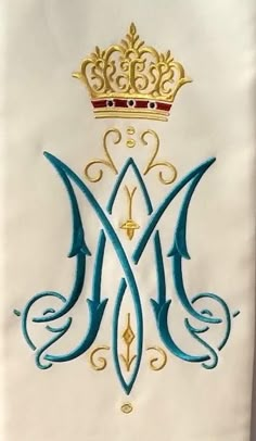 the letter m with a crown on top is painted in gold and blue ink,