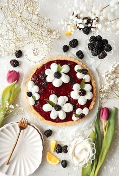 a pie topped with berries and marshmallows on top of a table