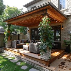 an outdoor living area with couches and plants on the deck, surrounded by greenery