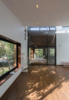 an empty room with wooden floors and large windows