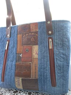 a denim bag with leather handles and zippers