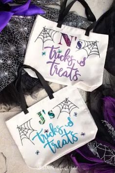 two trick or treat bags with spider webs on them