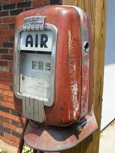 an old air meter sitting on the side of a building