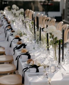 a long table with white flowers and black ribbon