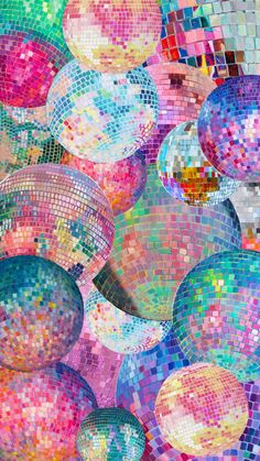 many disco balls are in the middle of a colorful wallpapered area with lots of different colors