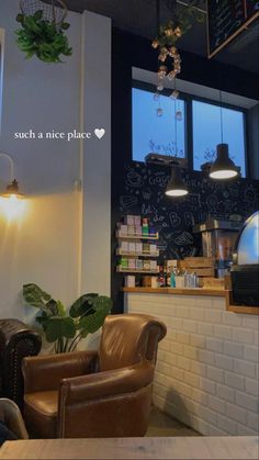 the inside of a coffee shop with two chairs and a chalkboard on the wall