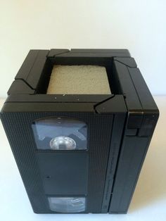 an old fashioned cassette player with sand in it's back compartment, sitting on a white surface