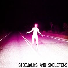 a person standing on the side of a road at night