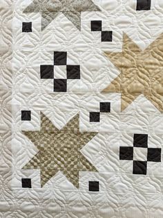 a white quilt with black and gold stars on it