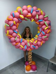 a woman standing in front of a giant balloon wreath