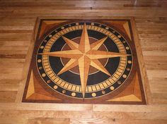 a wooden floor with a compass design on the top and bottom part inlayed to it