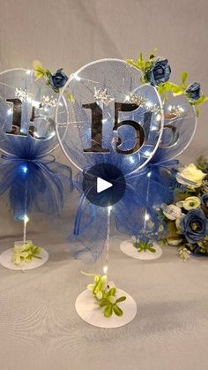 two clear glass vases with blue flowers on them and the number five displayed in front