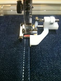 the sewing machine is being used to sew jeans