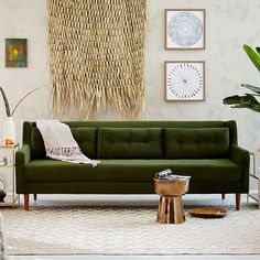 a living room with green couches and pictures on the wall above them, along with other furniture