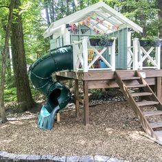 a playground with a slide and play set in the woods