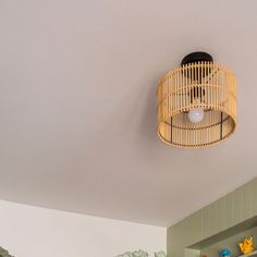 a wicker light fixture hangs from the ceiling