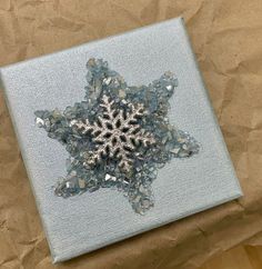 a snowflake made out of glass sitting on top of a piece of paper