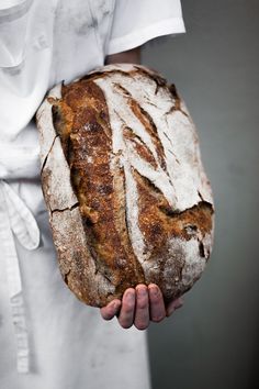 a person holding a loaf of bread in their hands