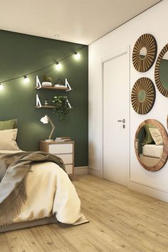 a bedroom decorated in green and white with round mirrors on the wall above the bed