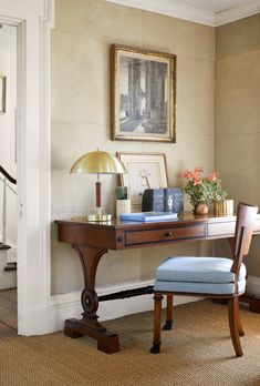 an image of a desk with a chair and pictures on it in the hallway area