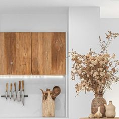 a kitchen with wooden cabinets and utensils hanging on the wall next to it