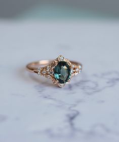 a close up view of a ring with an oval shaped blue stone and diamond accents