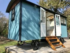 a blue and white tiny house on wheels