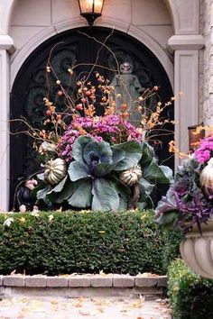 a vase filled with lots of flowers next to a building