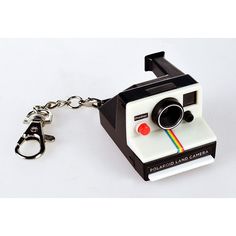 a polaroid camera keychain is shown on a white surface with a black handle