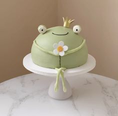 a frog cake with a flower on top